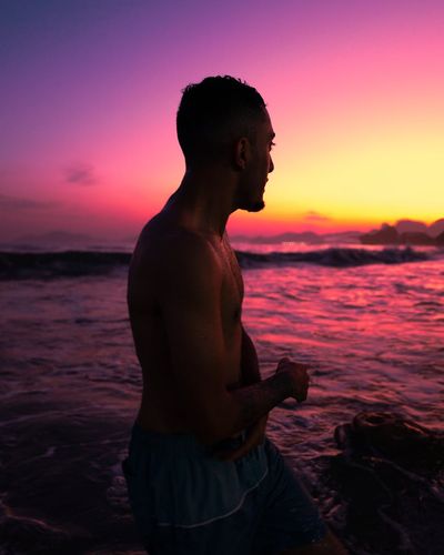 Silhouette of a man in a meditative pose at dusk.